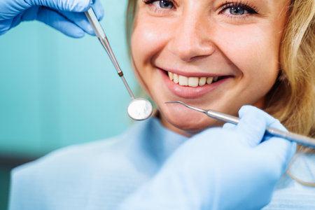 Close-up of the dentist's hands with medical devices. Large detail - dentist's mirror, curling and probe. Resolving dental problems effectively with confident, professional gestures.の写真素材
