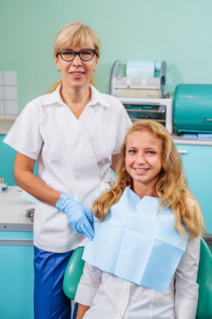 Portrait of a dentist and patient in a pleasant environment. The office has specialized equipment for the treatment of all types of dental diseases.の写真素材