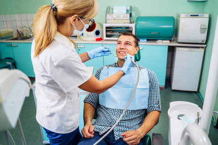 Close-up of a smiling, happy patient. Came for an examination to the clinic. No dental problems were found. Smooth, white teeth that do not require medical intervention. Big smile in the dental chair.の写真素材