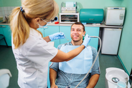Close-up of a smiling, happy patient. Came for an examination to the clinic. No dental problems were found. Smooth, white teeth that do not require medical intervention. Big smile in the dental chair.の写真素材