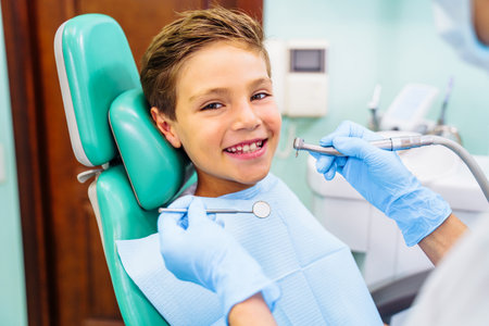 A cute baby is being examined by a professional pediatric dentist. Very happy boy after the visiting of doctor at the clinic with beautiful white smiles. Copy space.の写真素材