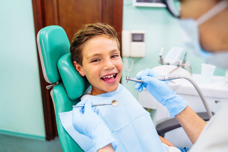 Patient with open mouth in dental clinic. Preparation for dental treatment. Using cotton wool to collect saliva, bor machine, dental mirror, tweezers and other devices. Timely treatment is important.の写真素材