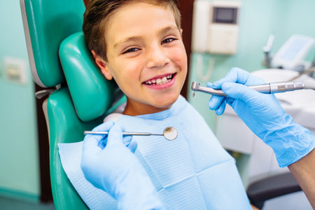 Dental inspection is being given to Beautiful man surrounded by dentist and his assistant. Woman dentist in the dental office talking to the patient and getting ready for treatment.の写真素材