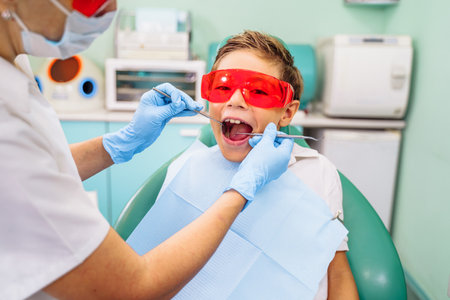 Protection of vision, eyesight against bright light and radiation from dental device with red or orange specialized glasses. Patient comfort comes first. Appointment at professional dentist in clinic.の写真素材