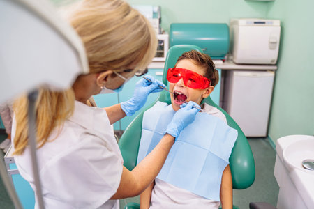 Protection of vision, eyesight against bright light and radiation from dental device with red or orange specialized glasses. Patient comfort comes first. Appointment at professional dentist in clinic.の写真素材