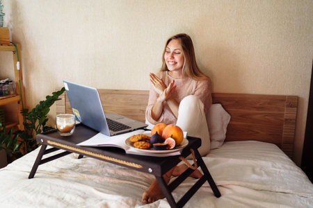 Attractive, blonde Caucasian ethnicity emotionally communicates via video, using tablet or computer. Adds gestures to speech. Looking at screen in front of her and showing stop sign, arms crossed.の写真素材
