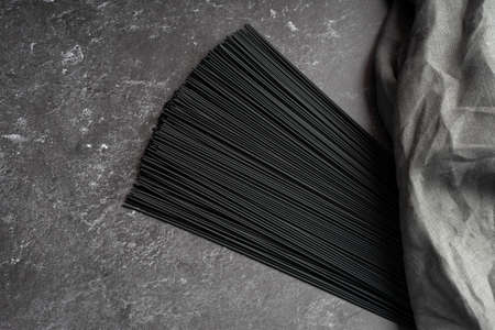 Black dry raw noodles spaghetti on dark backgroundの写真素材
