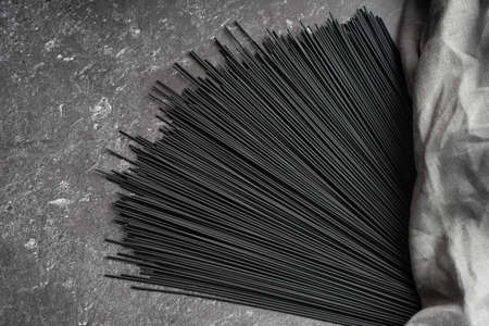 Black dry raw noodles spaghetti on dark backgroundの写真素材
