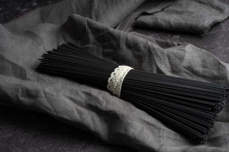 Black dry raw noodles spaghetti on dark backgroundの写真素材