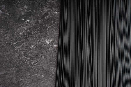 Black dry raw noodles spaghetti on dark backgroundの写真素材