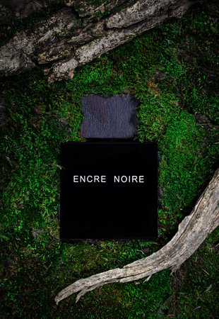 Kirov Russia 15 November 2020 Bottle of Encre Noire, Lalique. A men's eau de toilette. On a background of green moss in the forest and treeのeditorial素材