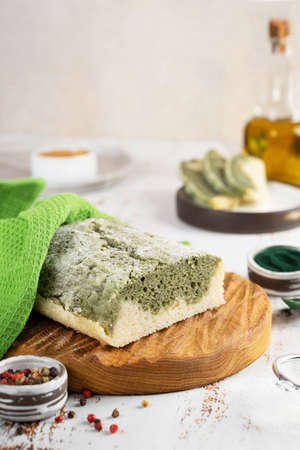Homemade Spirulina bread, made from gluten-free rice and flax flour On a wooden oak board. superfoods. Concept wellness and healthy vegeterian food. Close upの写真素材