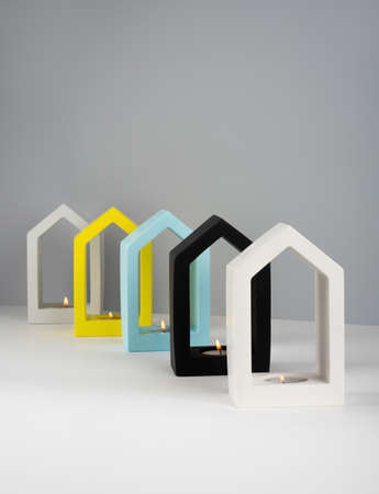 Creative composition. Still life. house-shaped concrete candlestick white, black, gray, bluevand yellow color with soy wax burning scented candle. Minimalismの写真素材