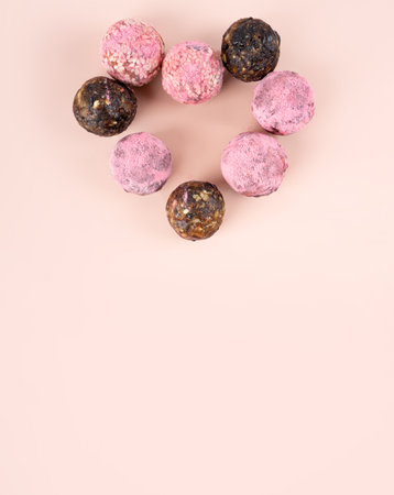 Homemade pink matcha energy balls dragon fruit hearth candy gift box february 14 valentine's day on a powder background top view, healthy sweets made of nuts and prunes. Concept postcard vegan dietの写真素材