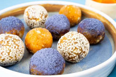 Homemade blue matcha energy balls in a ceramic bowl plate top view, healthy candy made of cashew...