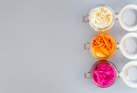 Homemade village fermented sauerkrauts, red cabbage and korean carrot in glass jars, gray...