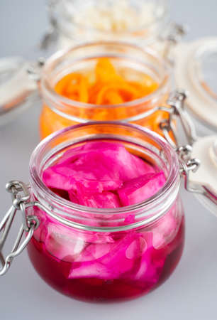 Homemade village fermented sauerkrauts, red cabbage and korean carrot in glass jars, gray...