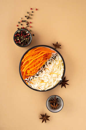 Homemade village fermented sauerkrauts and korean carrot. star anise, black and red pepper. Vegan salad in ceramic bowl. Probiotics gut health concept. Superfood on Creative beige background, top viewの写真素材