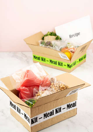 Online Home Food Delivery. Craft Box with packed tuna, shrimp, vegetables and recipe card on a...