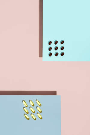 Vitamin capsules. lecithin pills and omega 3 pill on pink and blue background.trendy shadows....