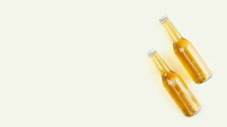 A two bottles of craft beer on light beige background. International beer day or Octoberfest concepts.Resting and Drinking beer after a hard working day in the home.Minimalistic photo.Copy space.の写真素材
