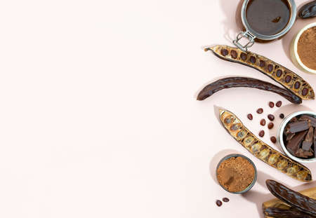 Organic carob pods, seeds in a ceramic plate on a beige background, locust bean healthy food, Ceratonia siliqua harnup. Natural vegan eating. creative food background. Copy space. Top view.の写真素材
