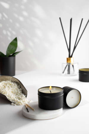 Soy wax candle in a black jar, and green leaf, plant on a white background. natural eco friendly organic wax candles. Trendy concept. minimalist. isometric projection. copy space.の写真素材