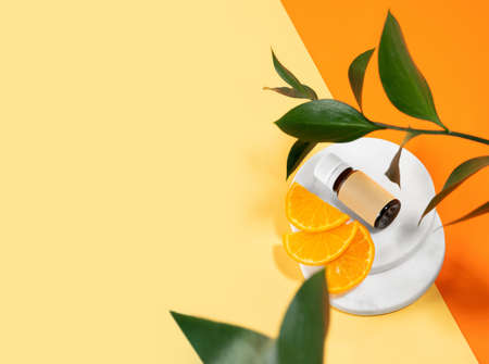 A package of anti-cellulite dry scrub lying on an orange background. Body scrub with essential oils of lime, coffee and mandarin. Cosmetic product for peeling and spa care, body beauty. copyspace.の写真素材