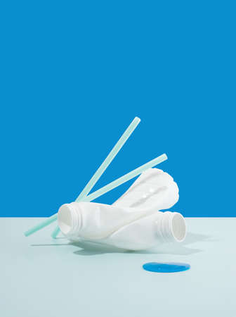 Plastic PET bottles, recycling symbol flying on a blue background. Plastic bottle fly and floating in the air. The idea of environmental sustainability. Concept of safety from environmental damage.の写真素材