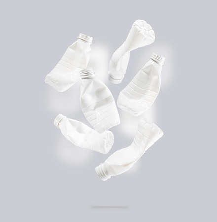 Plastic PET bottles, recycling symbol flying on a blue background. Plastic bottle fly and floating in the air. The idea of environmental sustainability. Concept of safety from environmental damage.の写真素材