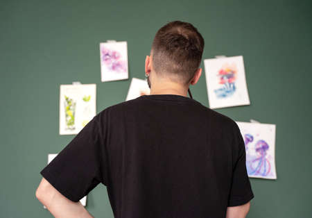 An art teacher checks his students' homework, standing at the school board in class.A drawing master. Art school concept, artist's studio, A smiling creative person. copy spaceの写真素材