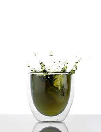 Glass of water with liquid chlorophyll and fresh herbs on a green table. Concept of superfood, eating healthy, detox and diet. Green background, copy spaceの写真素材