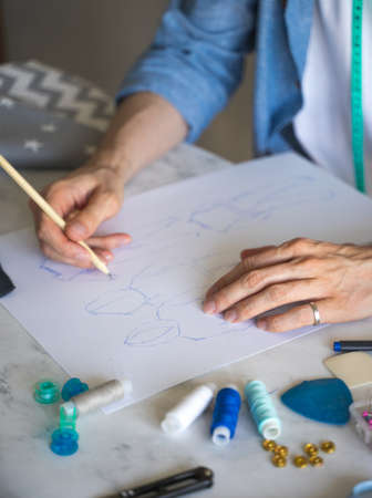 A male designer with glasses chooses the type of lace for sewing underwear. A self-taught seamster...