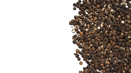 Pile of black peppercorns, a dried fermented seeds of Piper nigrum on a white background. Seasoning...