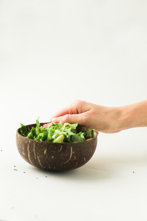 healthy vegan avocado and green salad in coconut bowlの写真素材