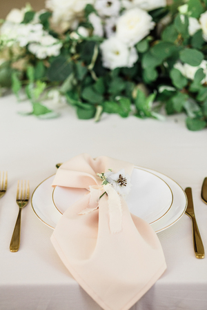 wedding table decorated by plates, knives and forks, candle, moss, flowers roseの写真素材