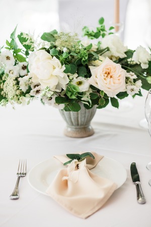 wedding table decorated by plates, knives and forks, candle, moss, flowers roseの写真素材