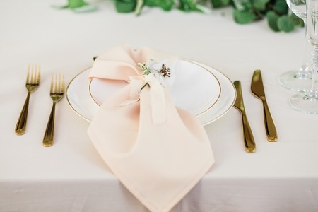 wedding table decorated by plates, knives and forks, candle, moss, flowers roseの写真素材