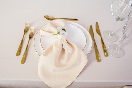 wedding table decorated by plates, knives and forks, candle, moss, flowers roseの写真素材