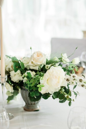 wedding table decorated by plates, knives and forks, candle, moss, flowers roseの写真素材