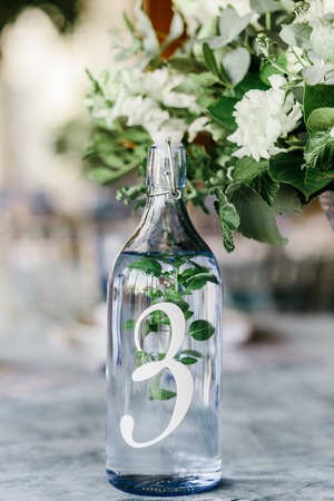 wedding table decorated by plates, knives and forks, candle, moss, flowers roseの写真素材