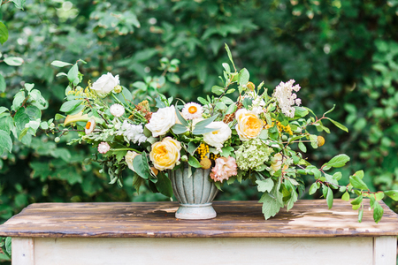 Wedding decor. Perfectly decorated holiday table for two with beautiful flower composition of fresh flowers in a vintage vaseの写真素材