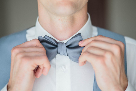 Grooms morning preparation, handsome groom getting dressed and preparing for the wedding, wearing cufflinksの写真素材