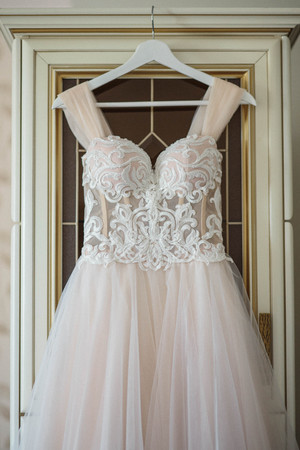 fine art beautiful wedding dress on hanger on a wall. Beautiful gownの写真素材