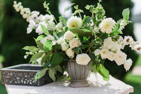 Wedding decor. Perfectly decorated holiday table for two with beautiful flower composition of fresh flowers in a vintage vaseの写真素材