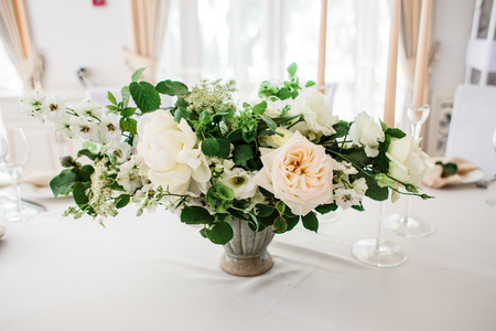 wedding table decorated by plates, knives and forks, candle, moss, flowers roseの写真素材