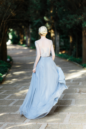 Stunning bride in beautiful wedding dress on natural background. The stunning young bride is incredibly happy. Wedding day. beautiful bouquetの写真素材