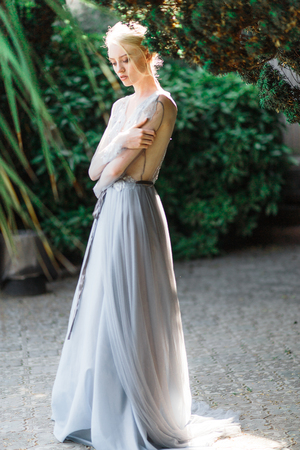 Stunning bride in beautiful wedding dress on natural background. The stunning young bride is incredibly happy. Wedding day. beautiful bouquetの写真素材