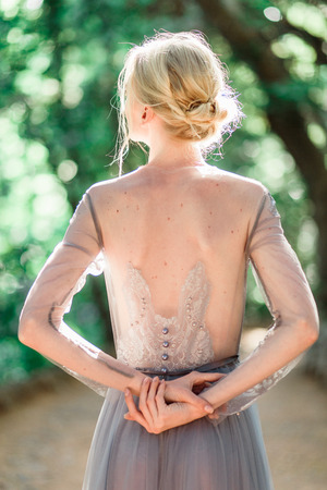 Stunning bride in beautiful wedding dress on natural background. The stunning young bride is incredibly happy. Wedding day. beautiful bouquetの写真素材