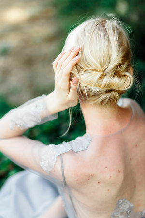 Stunning bride in beautiful wedding dress on natural background. The stunning young bride is incredibly happy. Wedding day. beautiful bouquetの写真素材